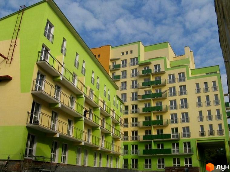 Житловий комплекс на вул. Бортнянського, 50 з яскравим фасадом та балконами. Прибудинкова територія з зеленими насадженнями.