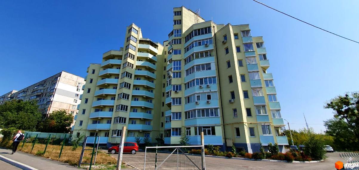 Сучасний житловий комплекс на вулиці Людвіга Свободи, біля №20. Будинок має жовто-блакитне оздоблення та багато балконів. Навколо зелена зона та парковка.