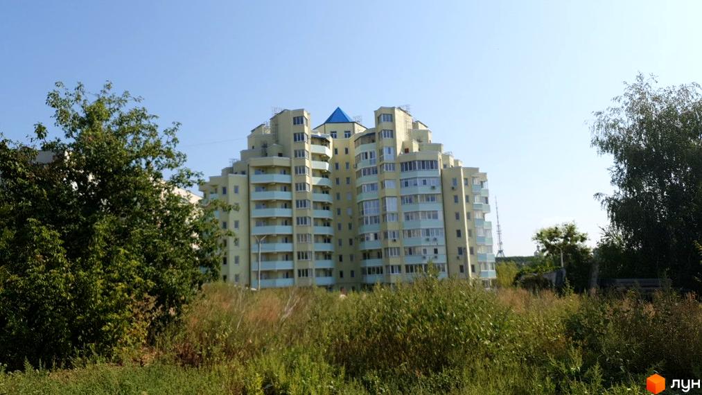 Житловий комплекс на вулиці Людвіга Свободи (біля №20) має багатоповерхову будівлю з балконами та вікнами. Навколо будівлі зелені дерева та трава.