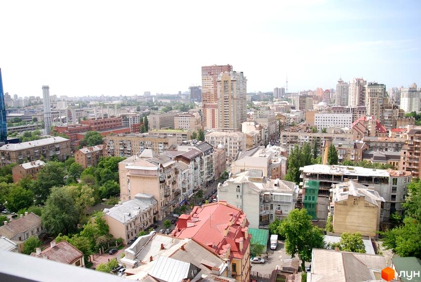 Вид на міський пейзаж з Житлового комплексу Саксаганський. Зображено різноповерхові будинки та зелені зони міста.