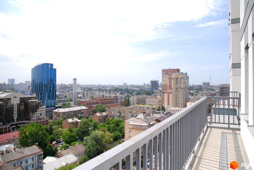 Панорамний вид з балкону Житлового комплексу Саксаганський на міську забудову, включаючи висотні будівлі та зелені насадження.