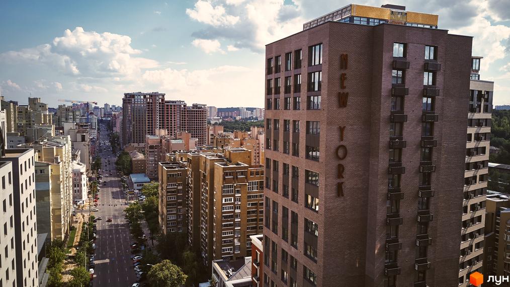 Вигляд на житловий комплекс New York Concept House з висоти пташиного польоту. Багатоповерховий будинок з великими вікнами та написом назви.