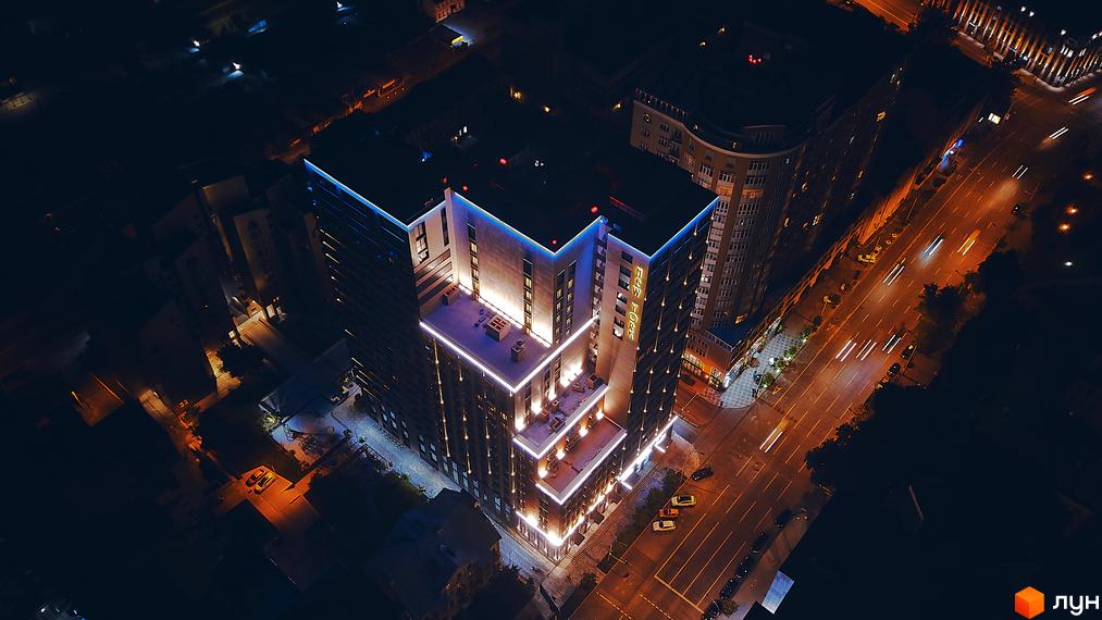 Зображення Новобудови New York Concept House вночі з підсвіткою. Вигляд зверху на будинок та дорогу з автомобілями.