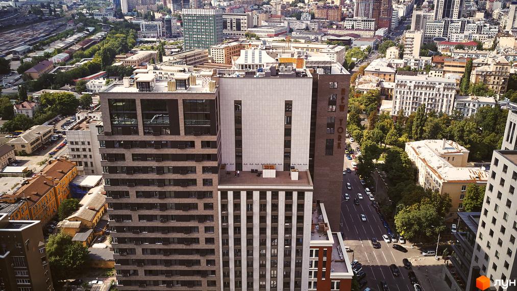 Зображення фасаду Новобудови New York Concept House з висоти пташиного польоту. Вигляд на вулицю з автомобілями та зелені насадження.