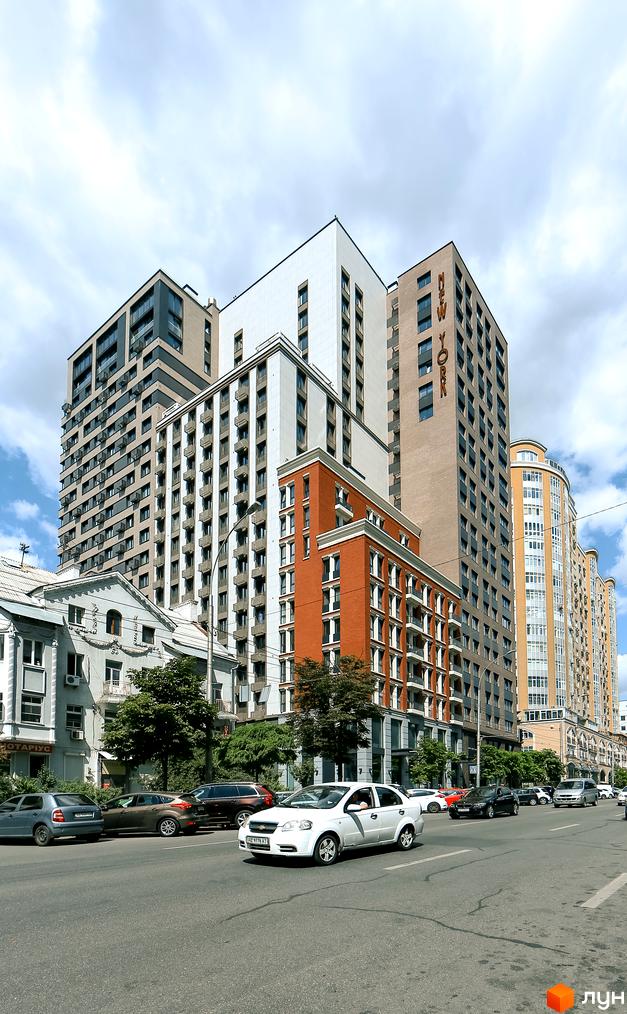 Зображення фасаду Житлового комплексу New York Concept House. Висотні будинки з великою кількістю вікон та балконів, вулиця з автомобілями.
