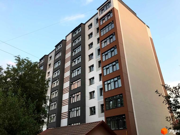 Сучасний житловий комплекс на вулиці Береговій 18/1, 18/2, 20 та вулиці Чистій, 23. Фасад будинку оздоблений білими, сірими та коричневими панелями.