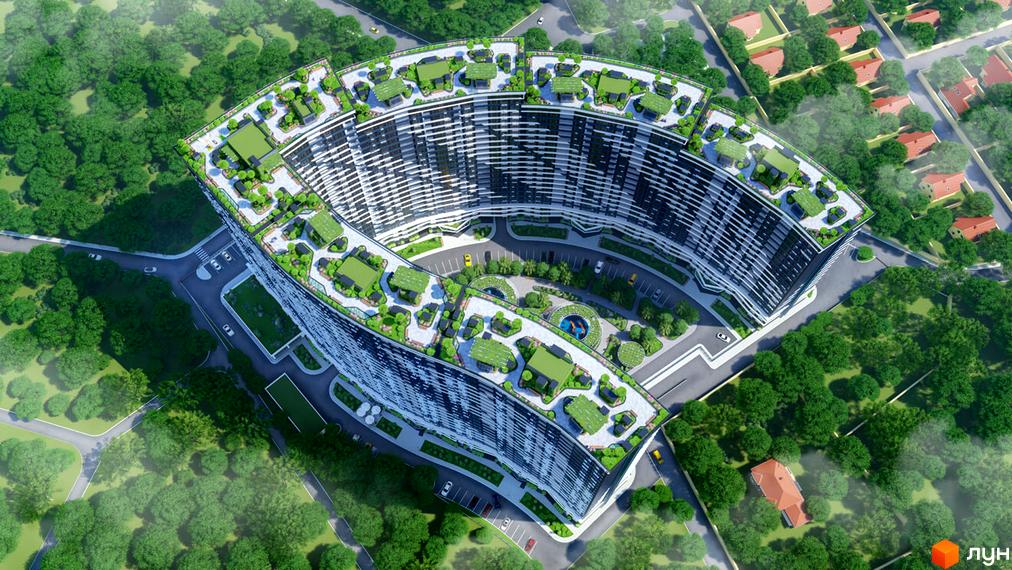 Вид зверху на вигнутий будинок ЖК Атмосфера з зеленими дахами та доглянутою прибудинковою територією з деревами, газонами та місцями для відпочинку.