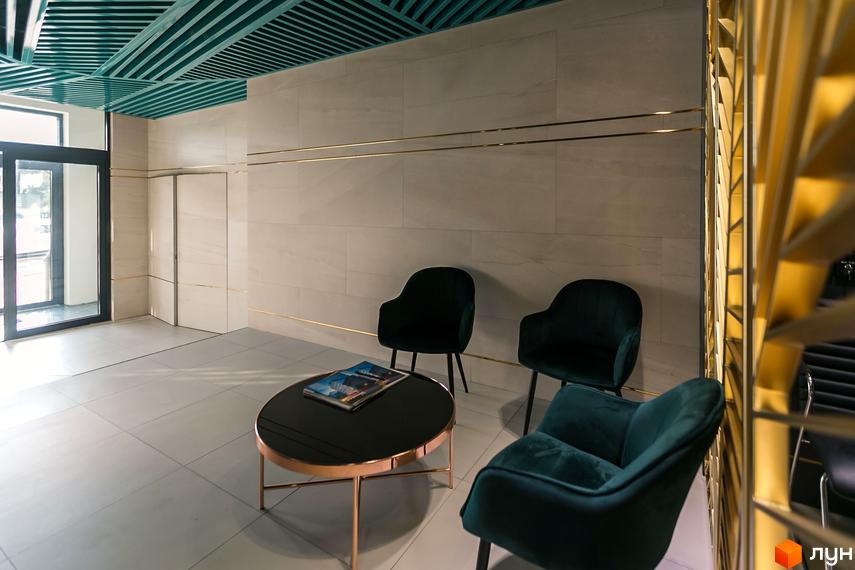 Einstein Concept House: зона відпочинку з кріслами та кавовим столиком у вестибюлі новобудови. Дизайн інтер'єру з мармуровими стінами та зеленою стелею.