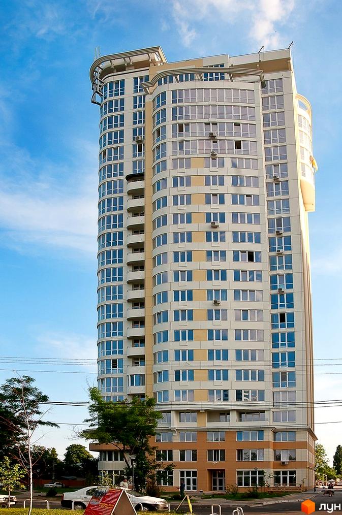 Житловий комплекс Руслан і Людмила з сучасним фасадом та великими вікнами, прибудинкова територія з зеленими насадженнями.
