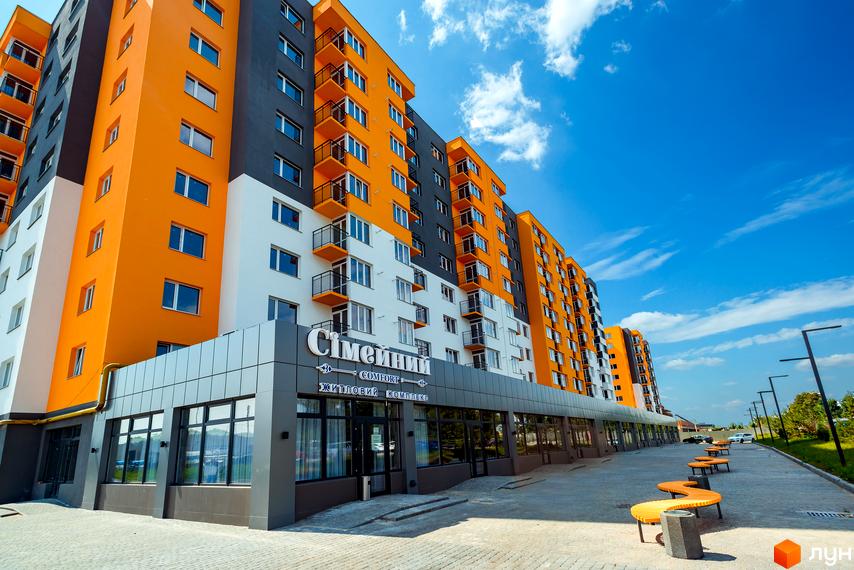 Житловий комплекс Сімейний COMFORT з яскравим фасадом та балконами. Навколо новобудови розташовані лавки та освітлення.