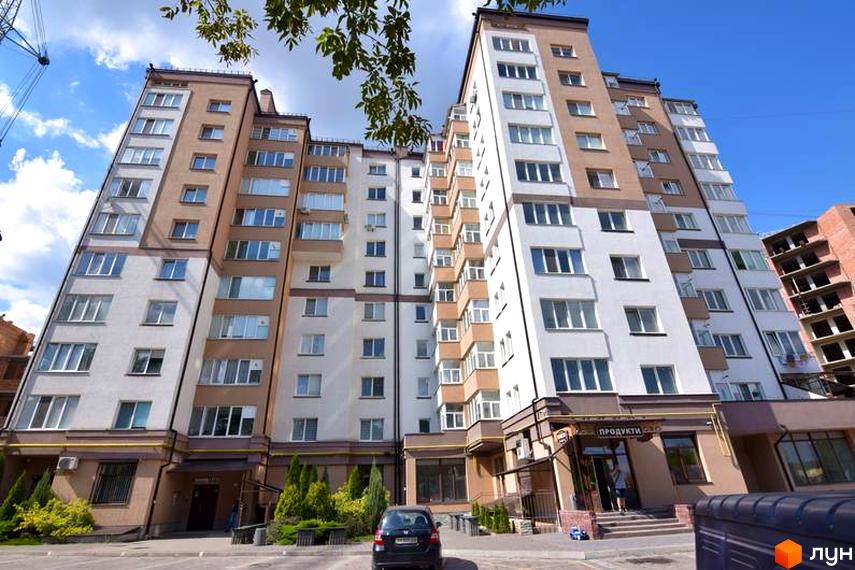 Зображення фасаду та прибудинкової території житлового будинку на вулиці Целевича, 4а. Багатоповерхова будівля з великими вікнами та доглянутим подвір'ям.