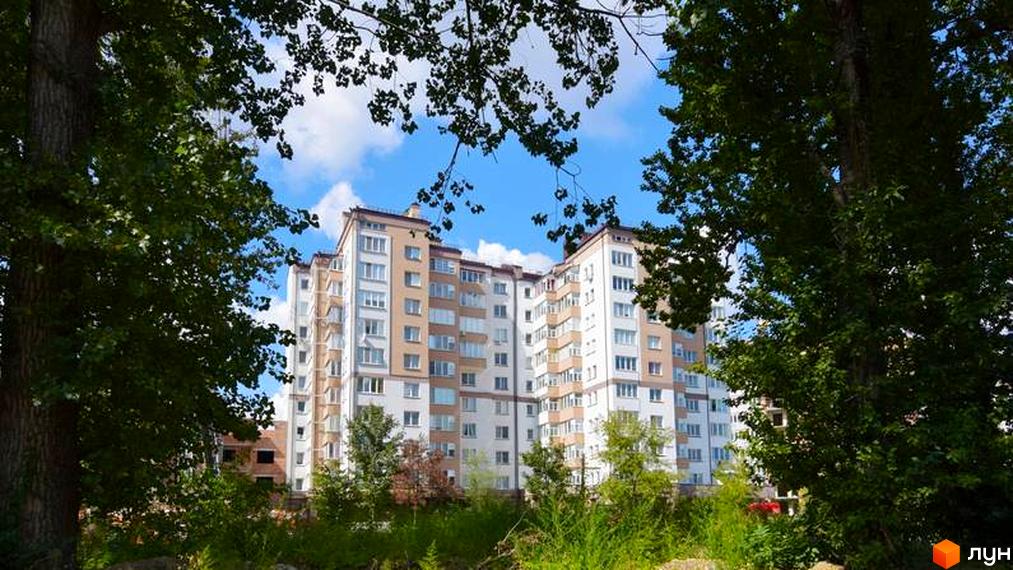 Зображення фасаду будинку по вулиці Целевича, 4а. Навколо будинку зелені насадження та дерева.