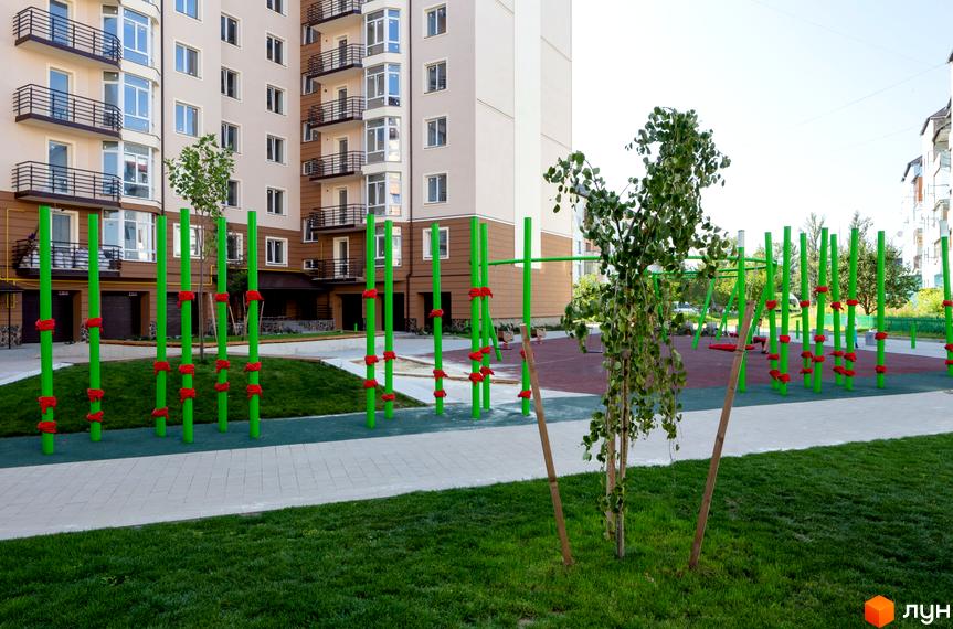 Житловий комплекс Нова оселя плюс з дитячим майданчиком. Сучасна новобудова з зеленими зонами та спортивними елементами для відпочинку.