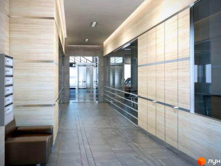 Клубний будинок New York: внутрішній хол з дерев'яними панелями, поштовими скриньками та диваном. Просторий коридор веде до входу зі скляними дверима.