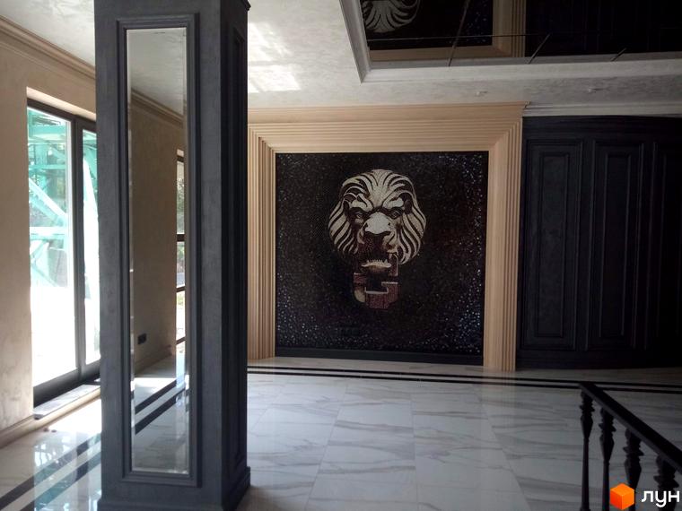 Інтер'єр клубного будинку Graf з мозаїчним панно у вигляді голови лева та дзеркальною колоною.