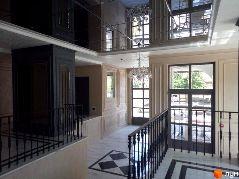 Інтер'єр клубного будинку Graf з елегантними люстрами та мармуровою підлогою. Простір оформлений у класичному стилі з акцентом на деталі.