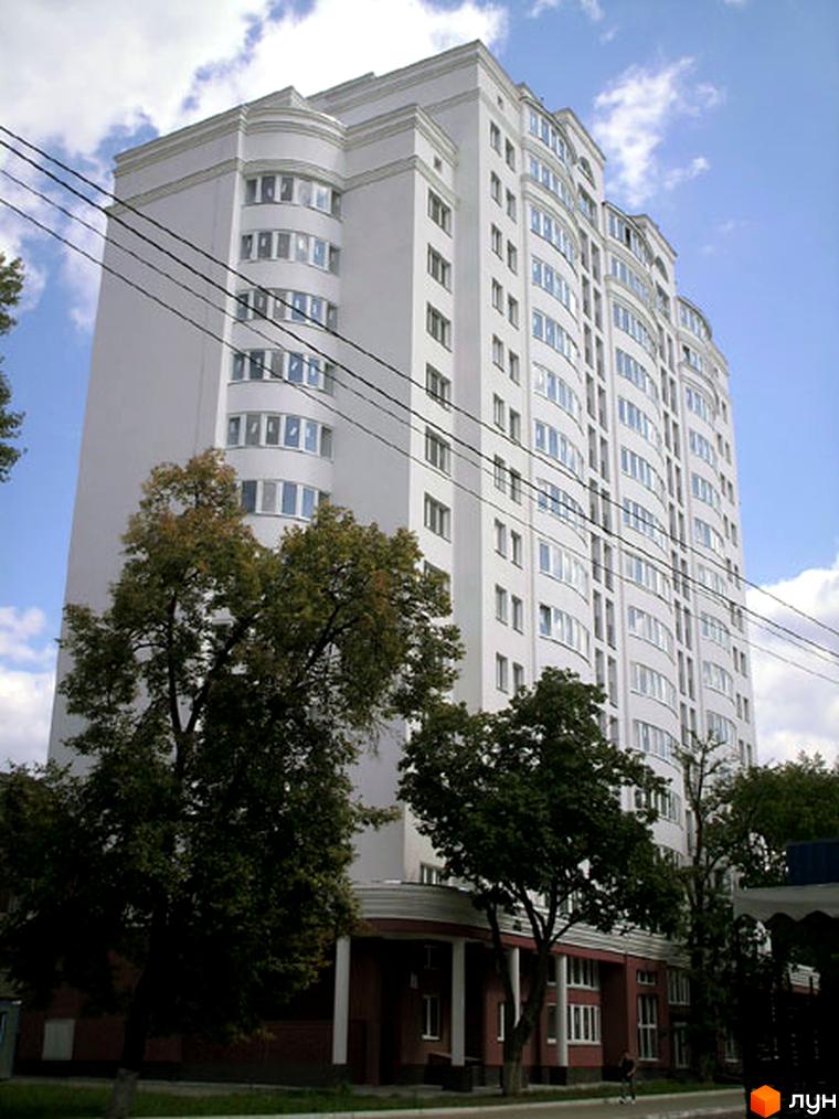 Вид на білий багатоповерховий будинок на вулиці Освіти, 3а, з елементами архітектурного оздоблення та зеленими деревами на передньому плані.