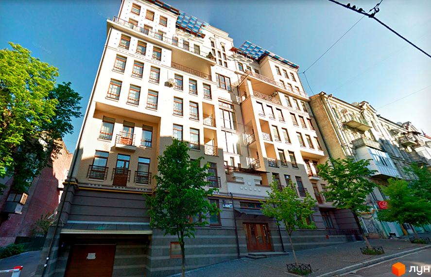 Зовнішній вигляд житлового комплексу Гончара 22 з багатьма вікнами та балконами. Навколо будинку розташовані дерева та тротуар.