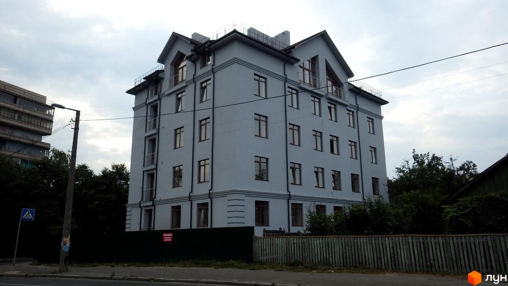 Будівельний проєкт на вул. Білицька, 108а. Сіра багатоповерхова новобудова з коричневими вікнами та балконами. Навколо зелені дерева та паркан.