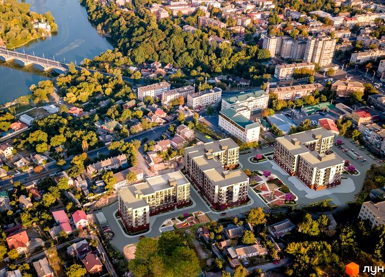 Аерофотозйомка житлового комплексу Родинний маєток з кількома багатоповерховими будинками та зонами відпочинку з дитячими майданчиками.