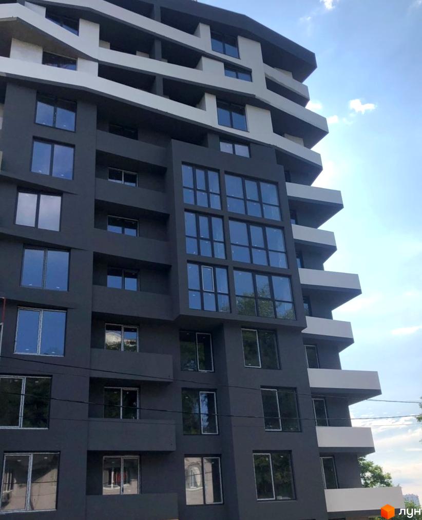 Зовнішній вигляд житлового комплексу Грін Парк: темний фасад, білі виступаючі елементи та численні вікна.