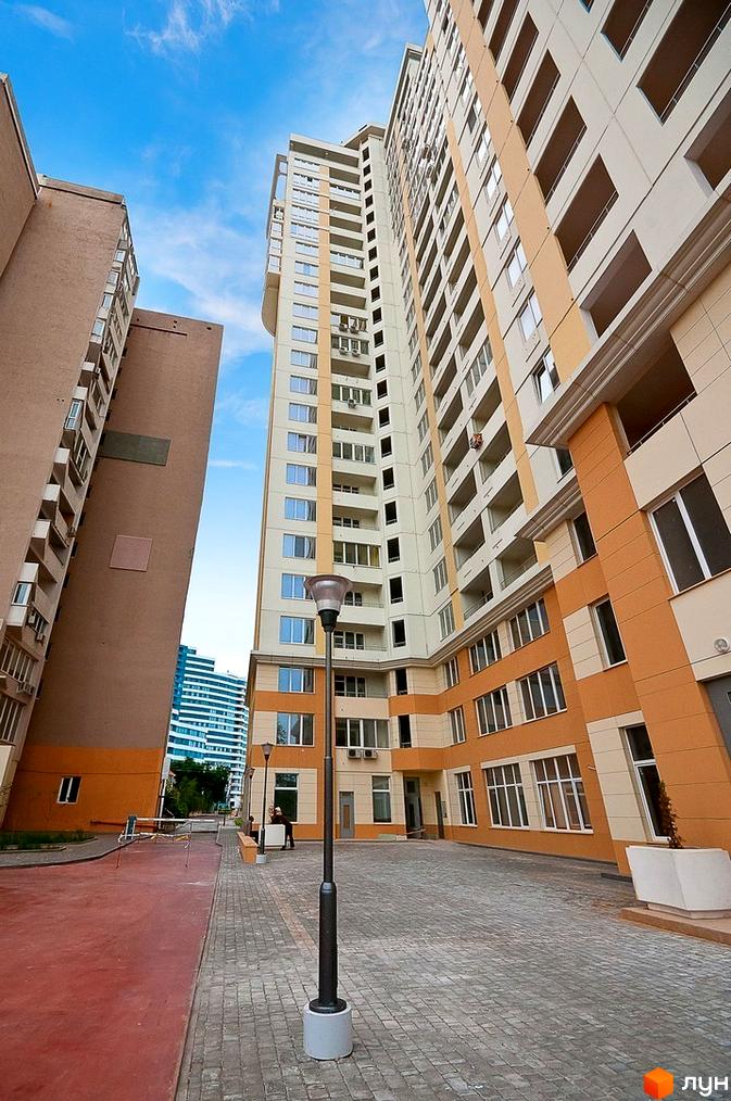 Житловий комплекс Руслан і Людмила з сучасними фасадами та прибудинковою територією, викладеною плиткою.