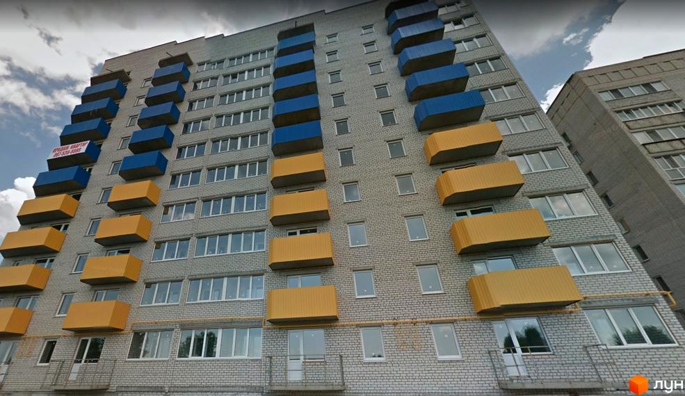 Фасад новобудови на вул. Конституції, 48, з жовто-синіми балконами. Будинок має багато вікон та цегляну облицювання.