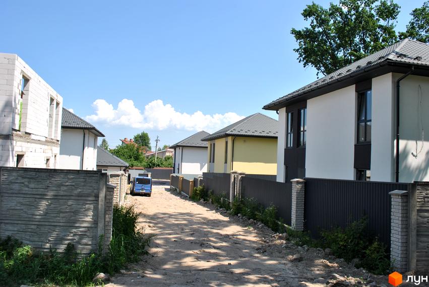 Будівельний проєкт на вул. Івана Франка, 34-36. На зображенні видно недобудовані будинки та паркан.