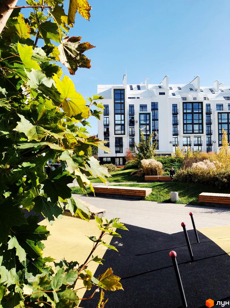 Зображення будинку в Житловому комплексі City Lake. На передньому плані зелені насадження та дитячий майданчик.