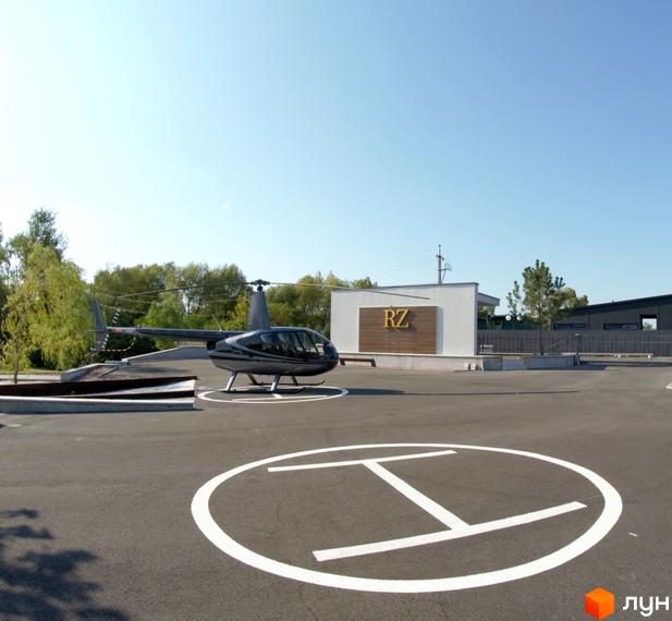 Гелікоптер на території Котеджного містечка KM Zолоче. На задньому плані будівля з написом RZ.