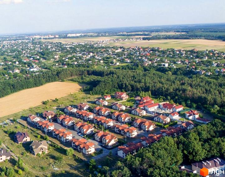 Вид на будинки КМ Садок Вишневий з висоти пташиного польоту. Червоні дахи будинків гармонійно поєднуються з навколишньою природою.