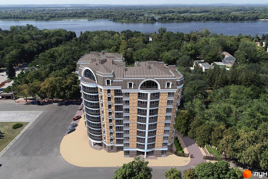 Зовнішній вигляд багатоквартирного будинку ЖК City Park з вигнутим фасадом та арочними вікнами на верхніх поверхах, що виходить на зелену зону та річку.
