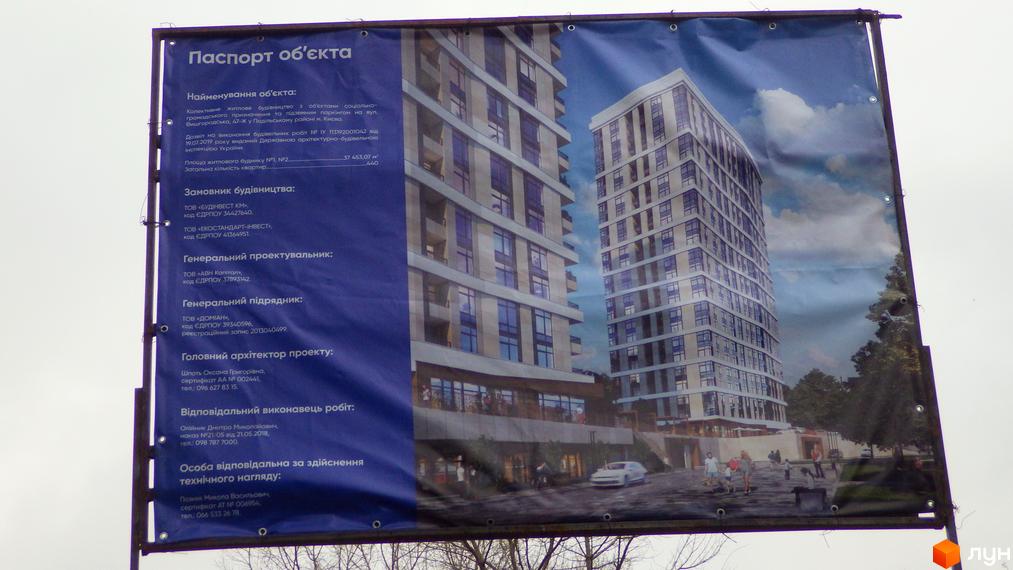 Житловий комплекс на Вишгородській, 47ж у Києві. Сучасна архітектура новобудови з великими вікнами та балконами, упорядкована прибудинкова територія з місцями для відпочинку та автомобілів.