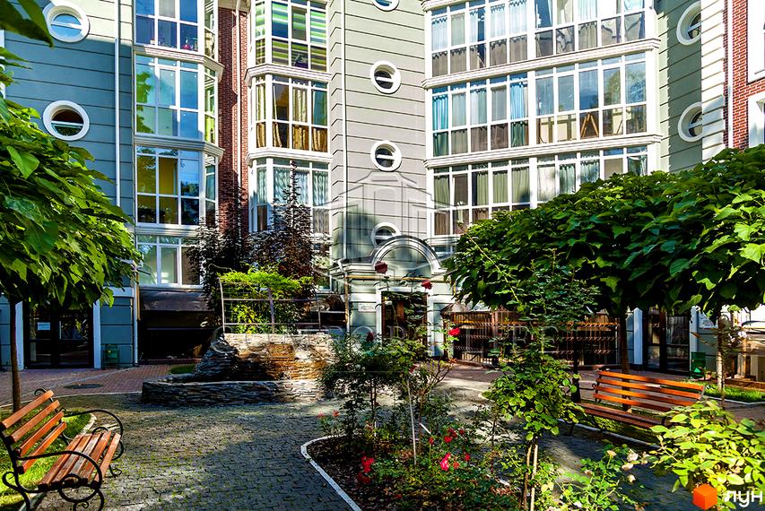 Житловий комплекс Британіка: фасади будівель з панорамними вікнами та балконами, зелена прибудинкова територія з лавками та квітами.