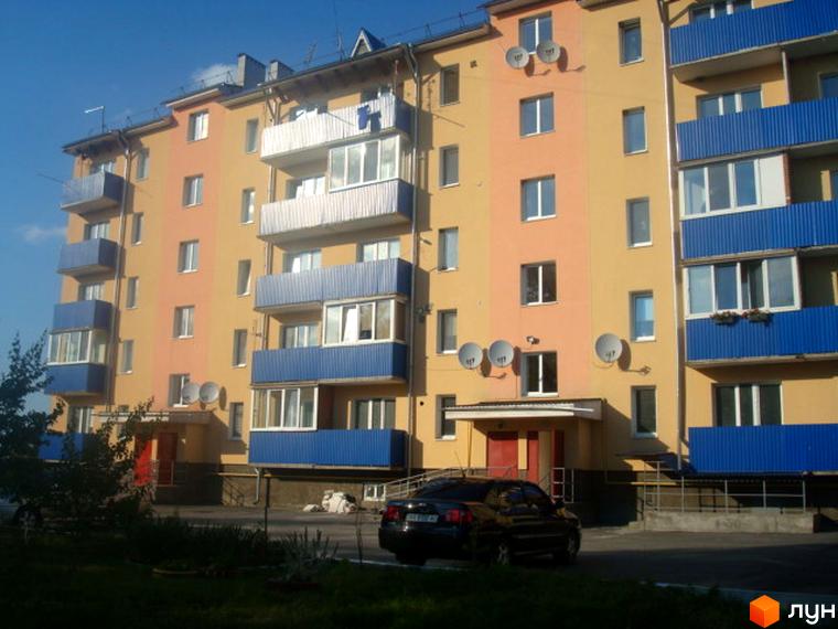 Житловий комплекс на вул. Заводська, 1г. Багатоповерховий будинок з балконами та супутниковими тарілками. На прибудинковій території видно припарковані автомобілі.
