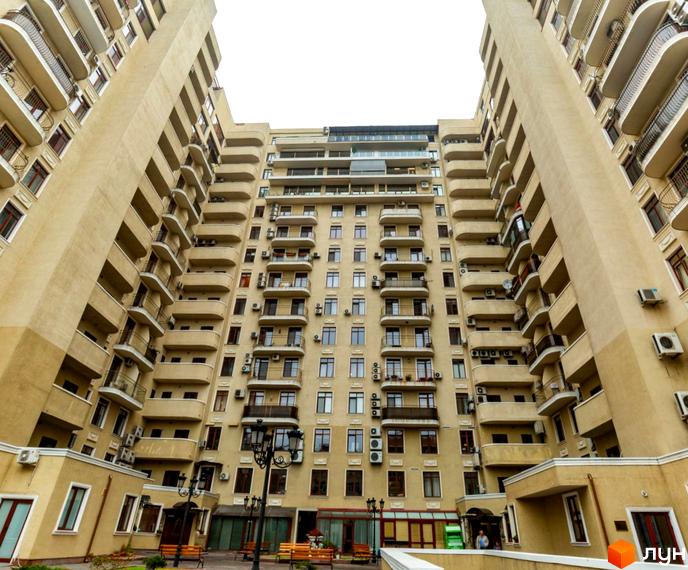 Житловий комплекс Будинок №1 - фасади багатоповерхових будинків з балконами та кондиціонерами, прибудинкова територія з лавками та ліхтарями.