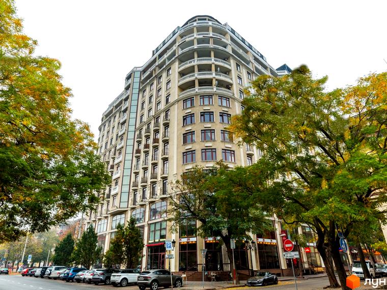 Житловий комплекс Будинок №1 - це багатоповерхова новобудова з балконами та великими вікнами, розташована на вулиці з деревами та припаркованими автомобілями.