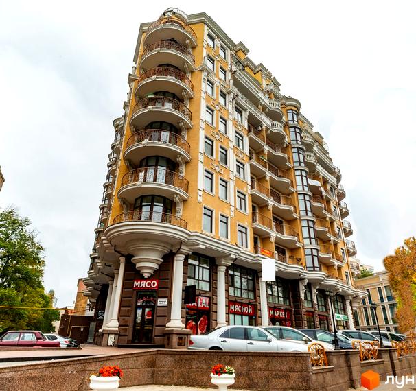 Житловий комплекс ЖК Крит з жовтою фасадною облицюванням та балконами. Прибудинкова територія з квітами та паркувальними місцями.