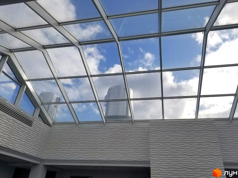 Скляна стеля в ЖК Санторіні з видом на хмарне небо. Архітектурний елемент з металевими конструкціями та скляними панелями.