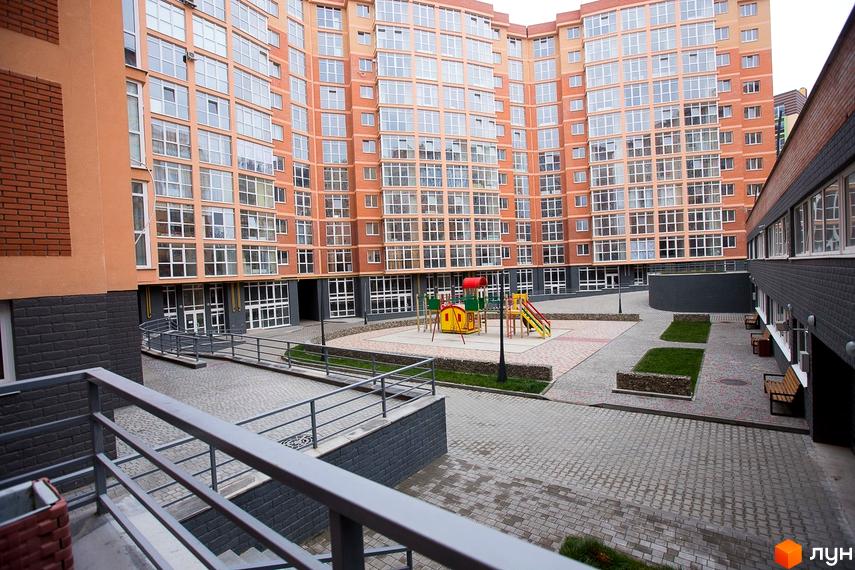 Житловий комплекс Перспектива: багатоповерховий будинок з помаранчевим фасадом. У дворі облаштовані дитячий майданчик та зони відпочинку.