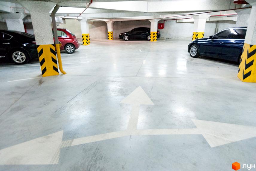 Паркінг житлового комплексу Наследие Дерибаса з вільними місцями для автомобілів та чіткою розміткою.