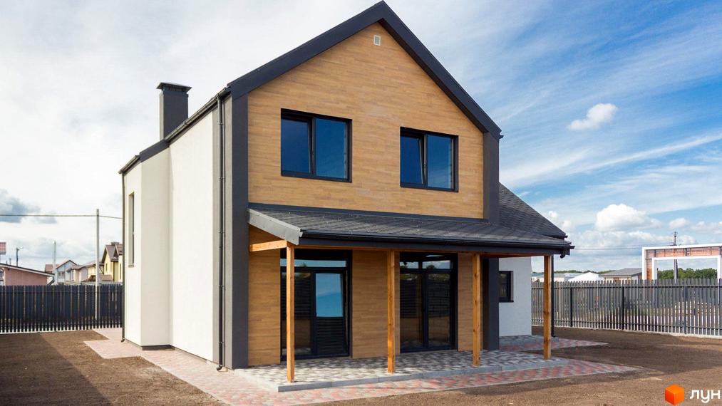 Котеджне містечко Нова Олександрівка: двоповерховий будинок з комбінованим фасадом, темною покрівлею та вікнами. Прибудинкова територія з бруківкою.