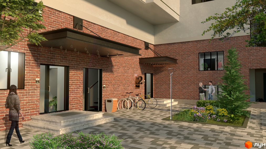 Фасад житлового комплексу Wellspring з червоної цегли та вхідною групою. Прибудинкова територія з деревами, квітами та велосипедами.