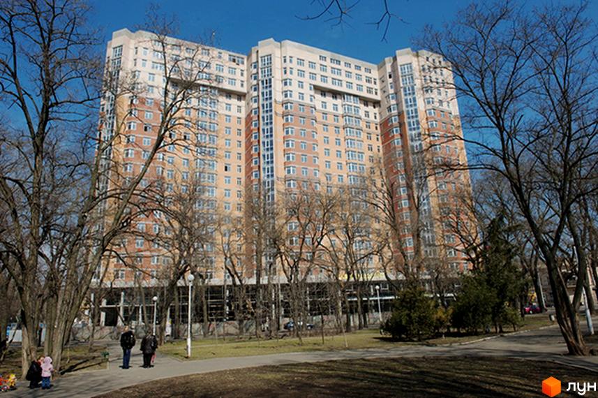 Житловий комплекс Усадьба Разумовского, висотна будівля з великими вікнами, оточена зеленими насадженнями та парком.