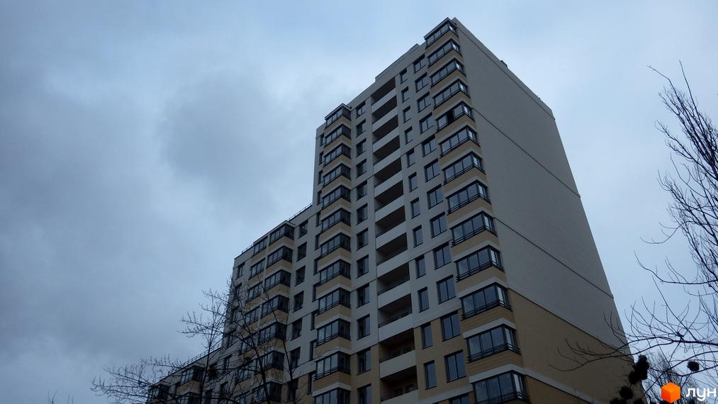 Багатоповерховий житловий будинок світлого кольору з балконами та вікнами на вул. Туманяна, 1а, під хмарним небом.