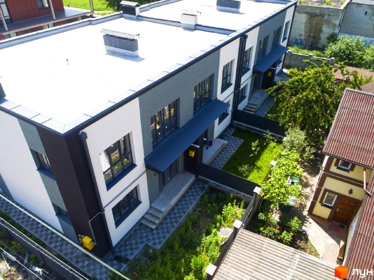 Таунхаус Престиж: будівлі з біло-сірими фасадами та темними вікнами, оточені доглянутими газонами.