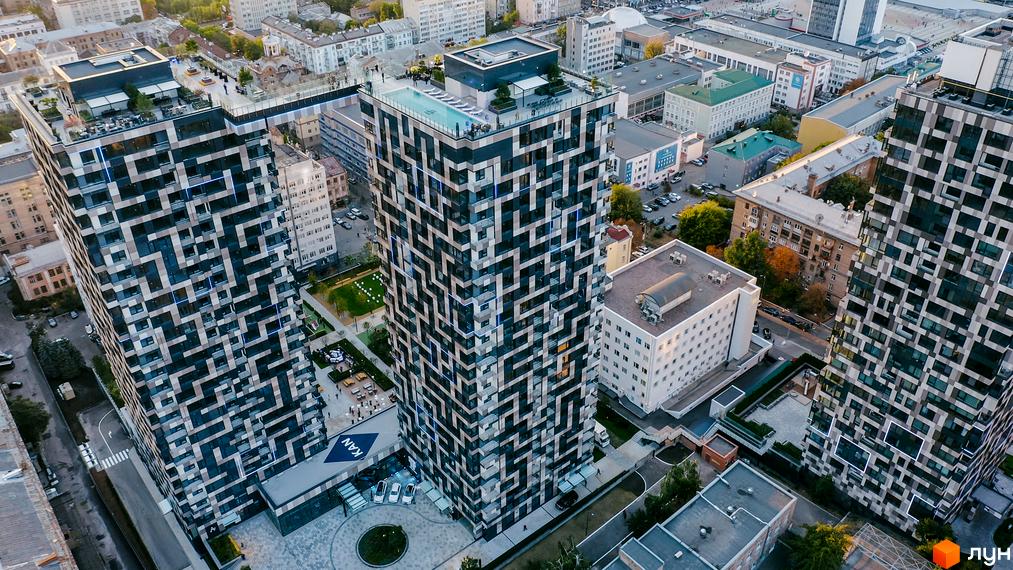 Житловий комплекс Tetris Hall з унікальним фасадом та басейном на даху. Навколо комплексу зелена зона та місця для відпочинку.