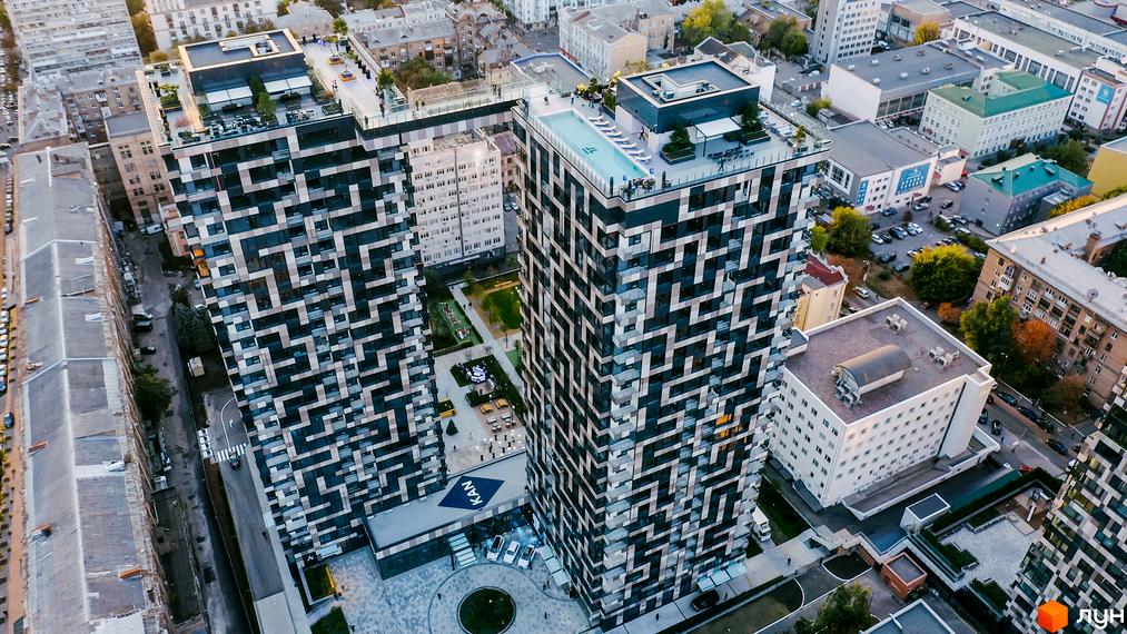 Житловий комплекс Tetris Hall з унікальним фасадом та басейном на даху. Навколо комплексу облаштована прибудинкова територія з зеленими зонами та місцями для відпочинку.