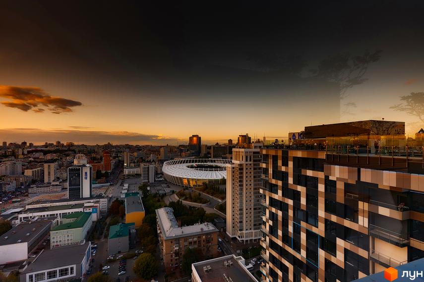 Вид на житловий комплекс Tetris Hall з висоти пташиного польоту на заході сонця. Комплекс має унікальний геометричний дизайн фасадів та розташований поруч зі стадіоном.