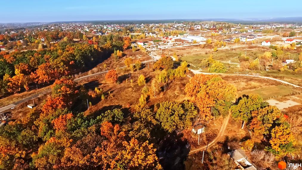 Вид на КМ Панорама з висоти пташиного польоту восени, що демонструє мальовничі краєвиди та зелені насадження навколо комплексу. Ознайомтеся з плануваннями та інфраструктурою цього житлового комплексу.